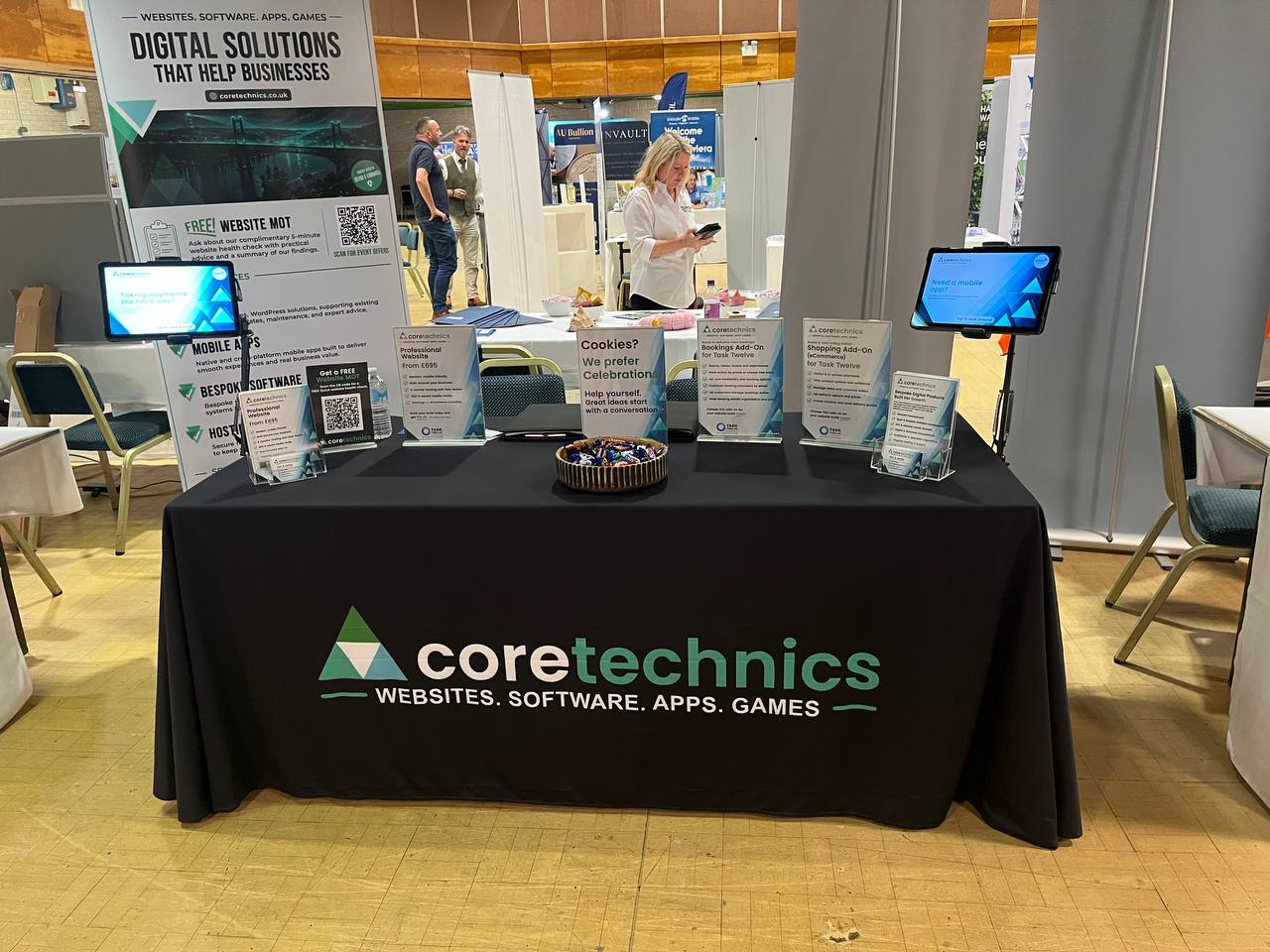 CoreTechnics information cards and digital displays arranged across the expo stand